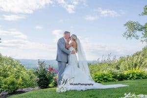 Couple kissing on top of a hill with flowers